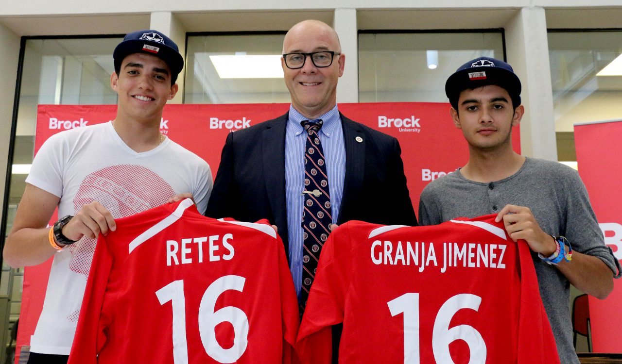International Award for Possibilities recipients Eduardo Retes, left, and Alex Granja Jimenez, right, were presented with Brock jerseys from Acting President Brian Hutchings Thursday in Market Hall during a pro-sports style announcement event.