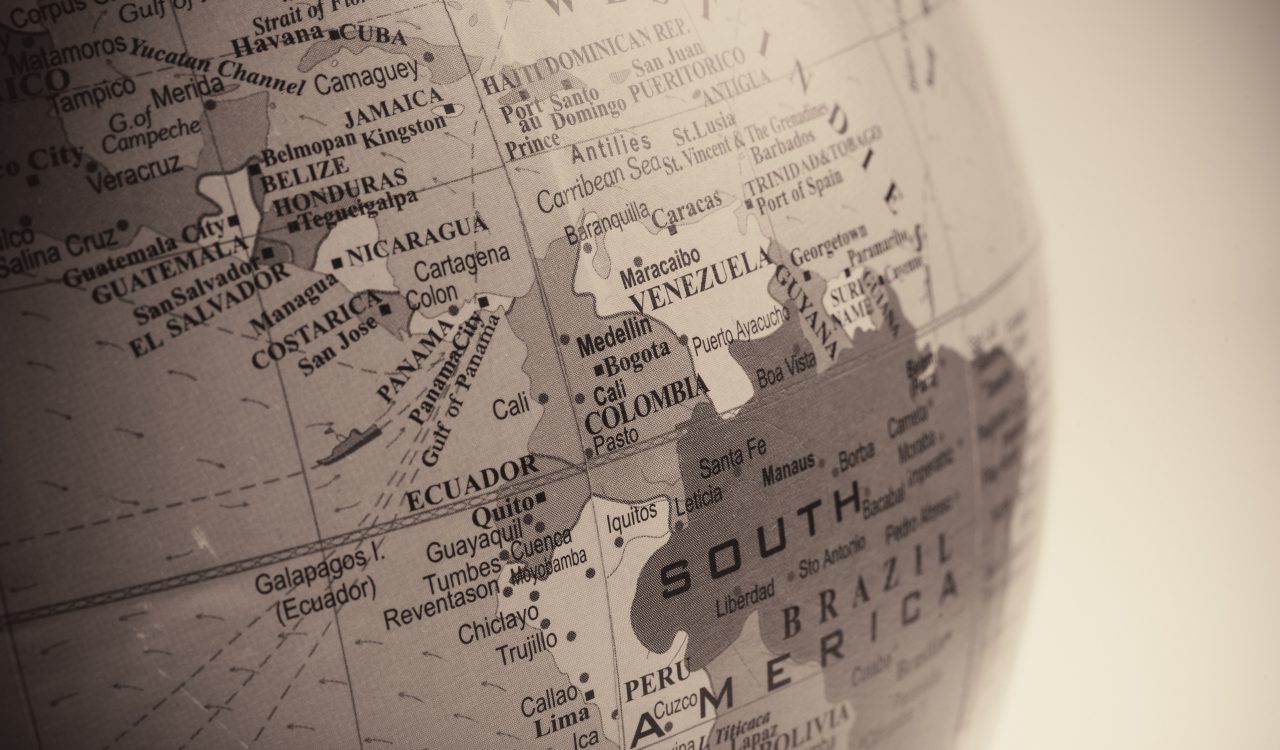 Map of countries on an old dusty globe against a white-isolated backdrop.