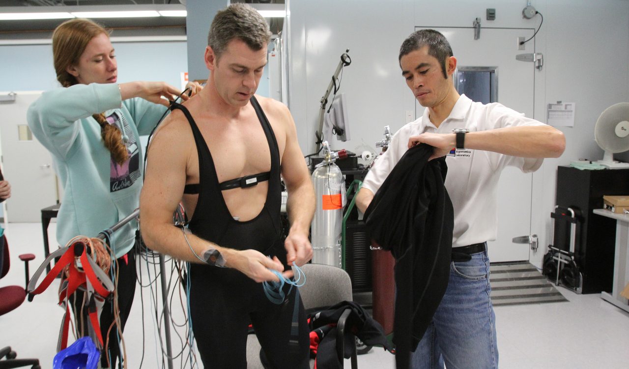 Stephen Cheung, right, and research assistant Tamara Zwaan prepare Mike Taber for a bicycle ride in Cheung's lab at Brock University.