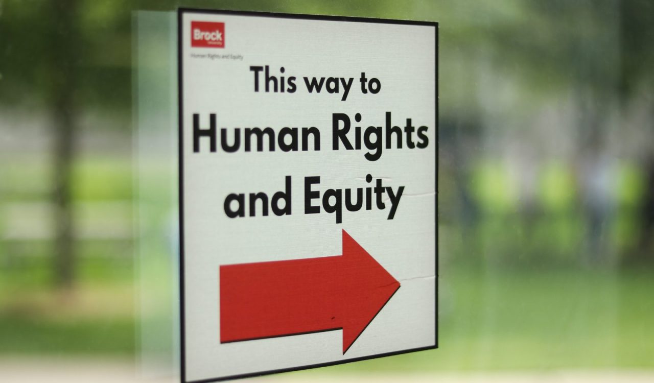 A sign on a window reads 'This way to Human Rights and Equity.'