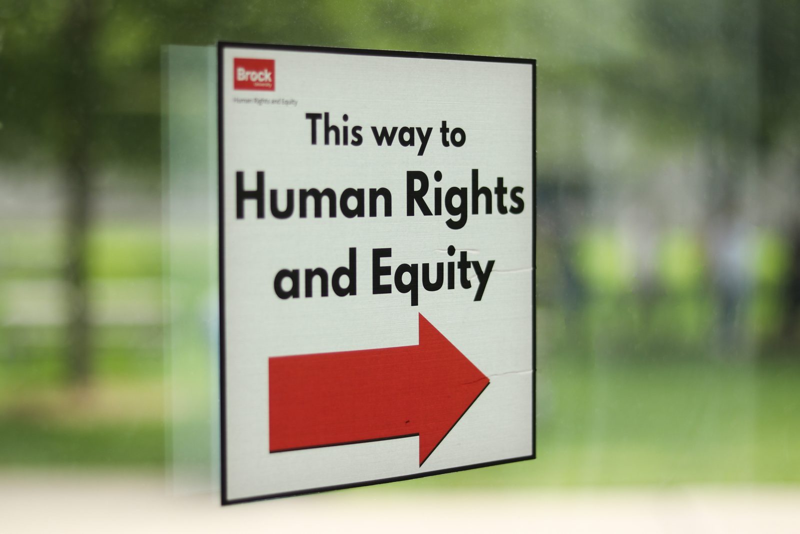A sign on a window reads 'This way to Human Rights and Equity.'