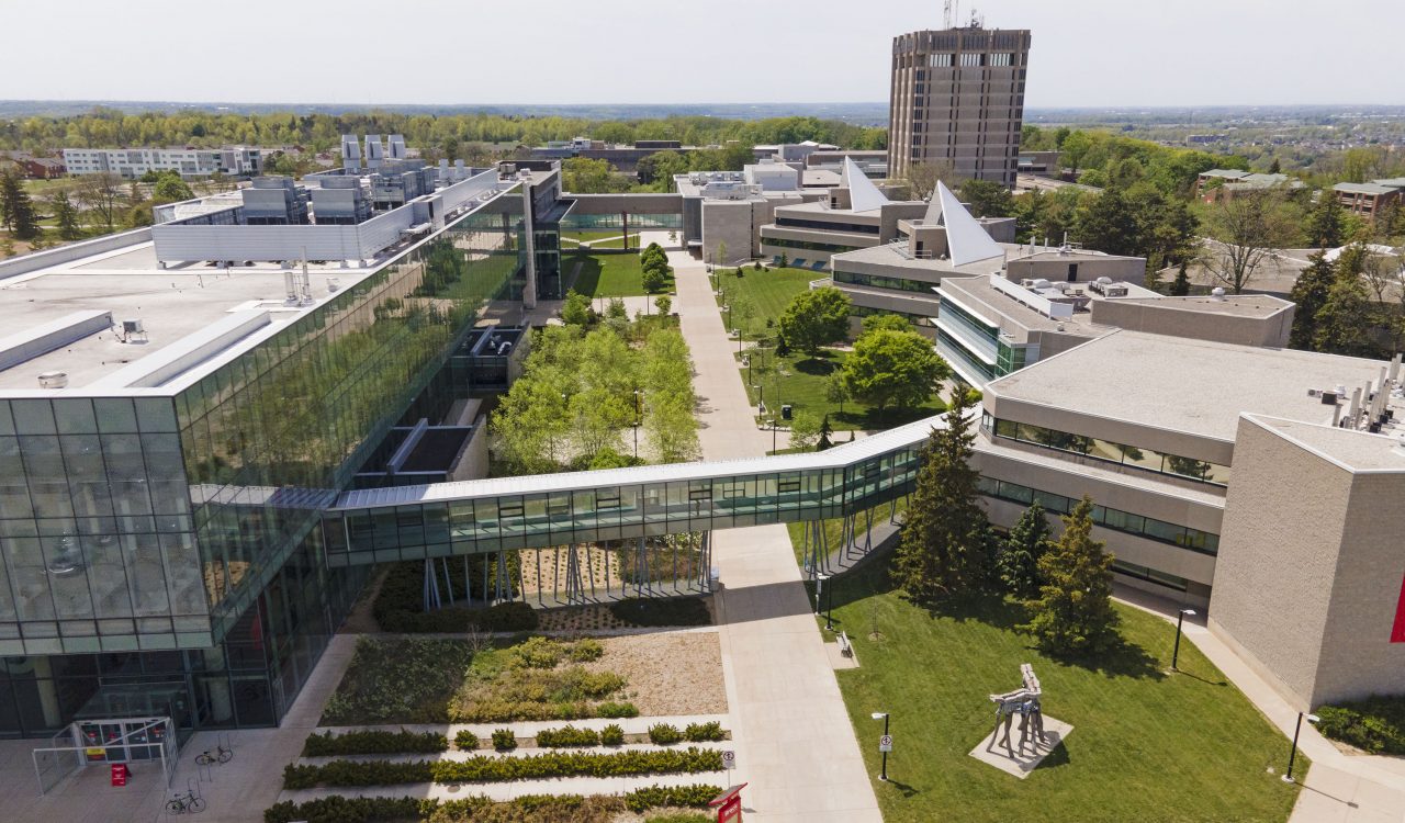 An aerial photo of Brock’s main campus with the Mackenzie Chown complex on the right, the Roy and Lois Cairns Health and Bioscience Research Complex on the left and the Schmon Tower in the distance.