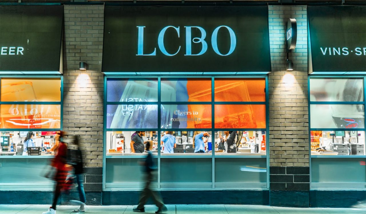 The exterior of an LCBO store with customers and staff visible through the windows.