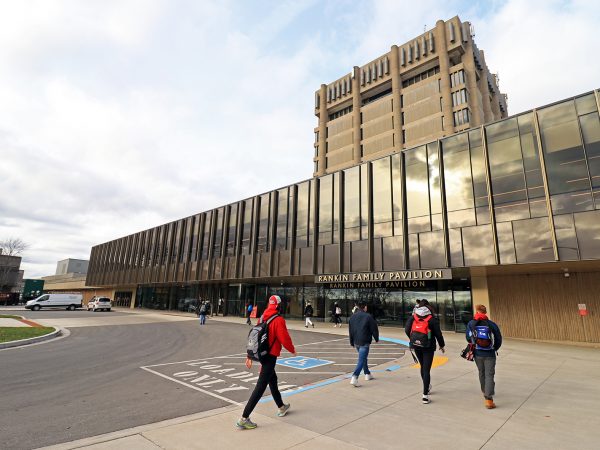 Four students walk in front of the Rankin Family Pavilion at Brock University.