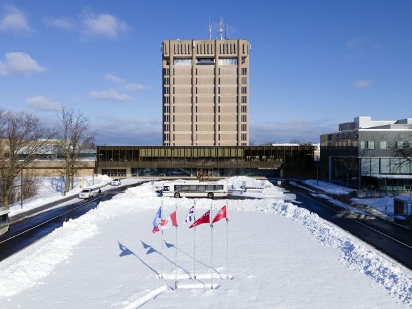 Brock University's Schmon Tower in front of a field of snow.