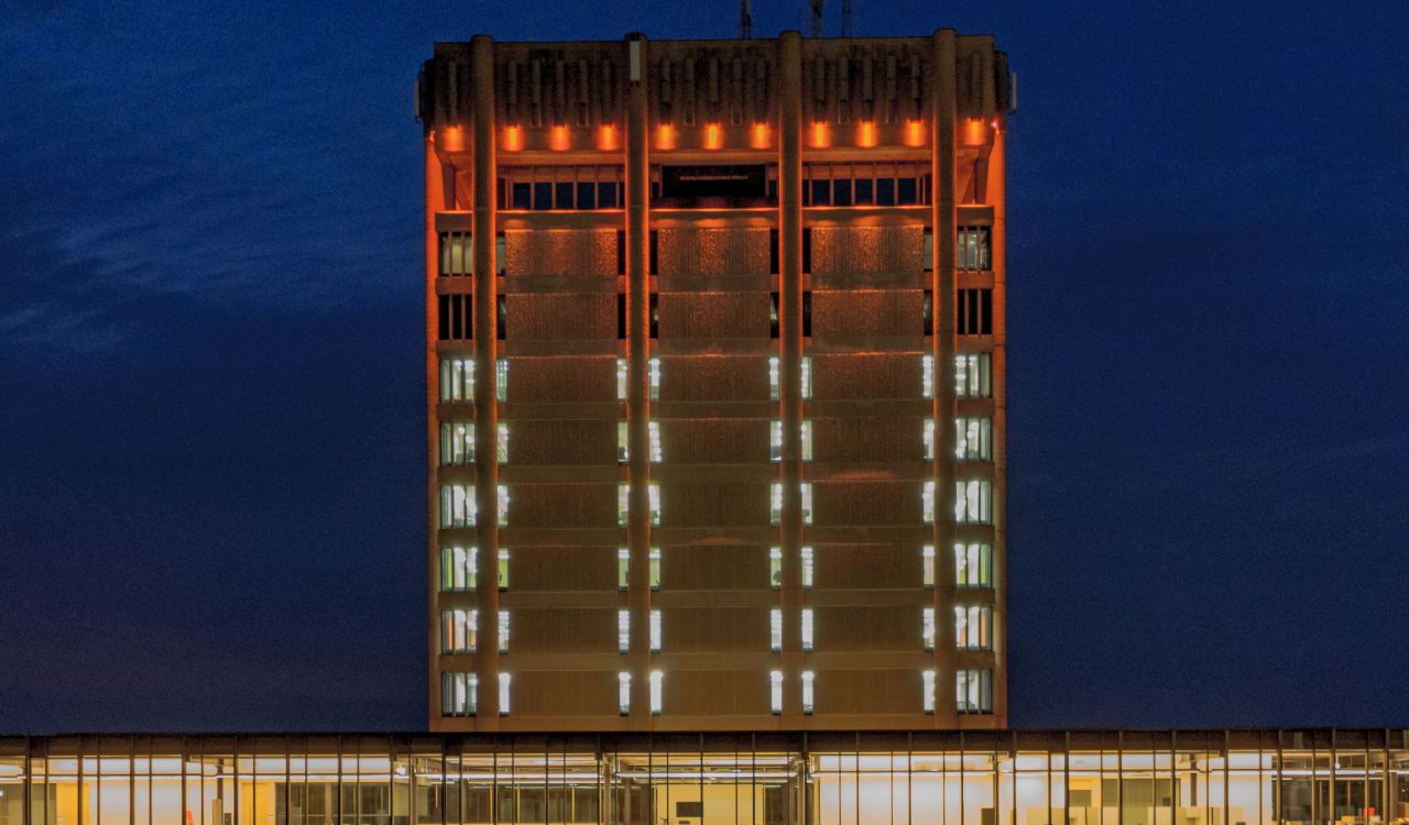 Brock University’s Schmon Tower is seen lit in orange at night.