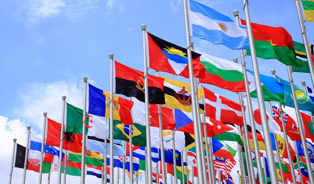 Flags of the world flying against blue sky