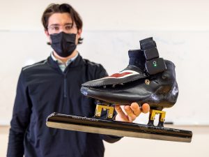 A man holds a speed skate equipped with tracking technology.