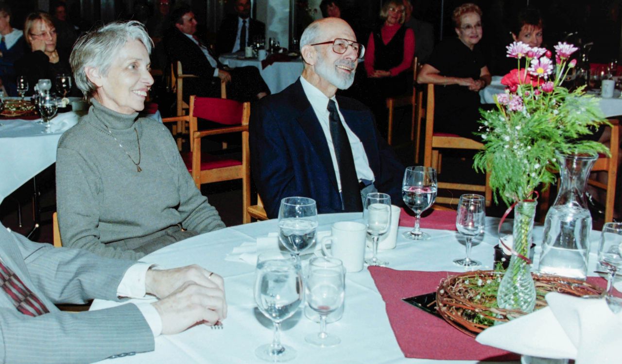Two men and a woman sit at a banquet table.