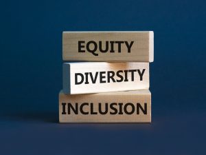 Three stacked wooden blocks read “Equity/Diversity/Inclusion” against a blue background