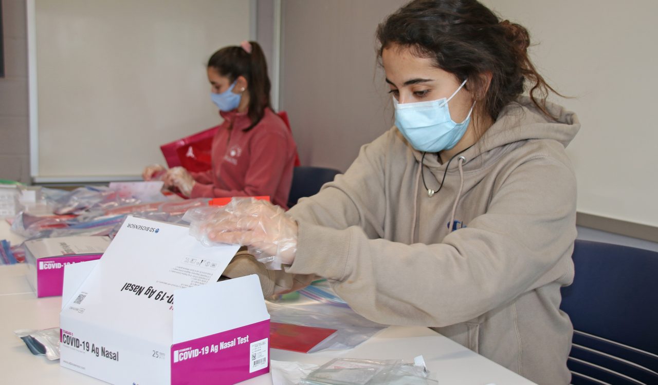 Two women wearing masks working at a table