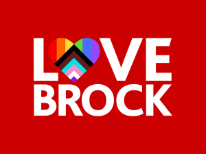 The words “LOVE BROCK’ written in white lettering on a red background. The ‘O’ in “LOVE” is shaped like a heart and contains red, orange, yellow, green, blue, purple, black, brown, seafoam, pink and white bars of the University’s all-inclusive flag.