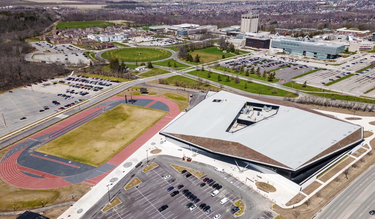 An aerial view of an athletics facility next to a university campus.