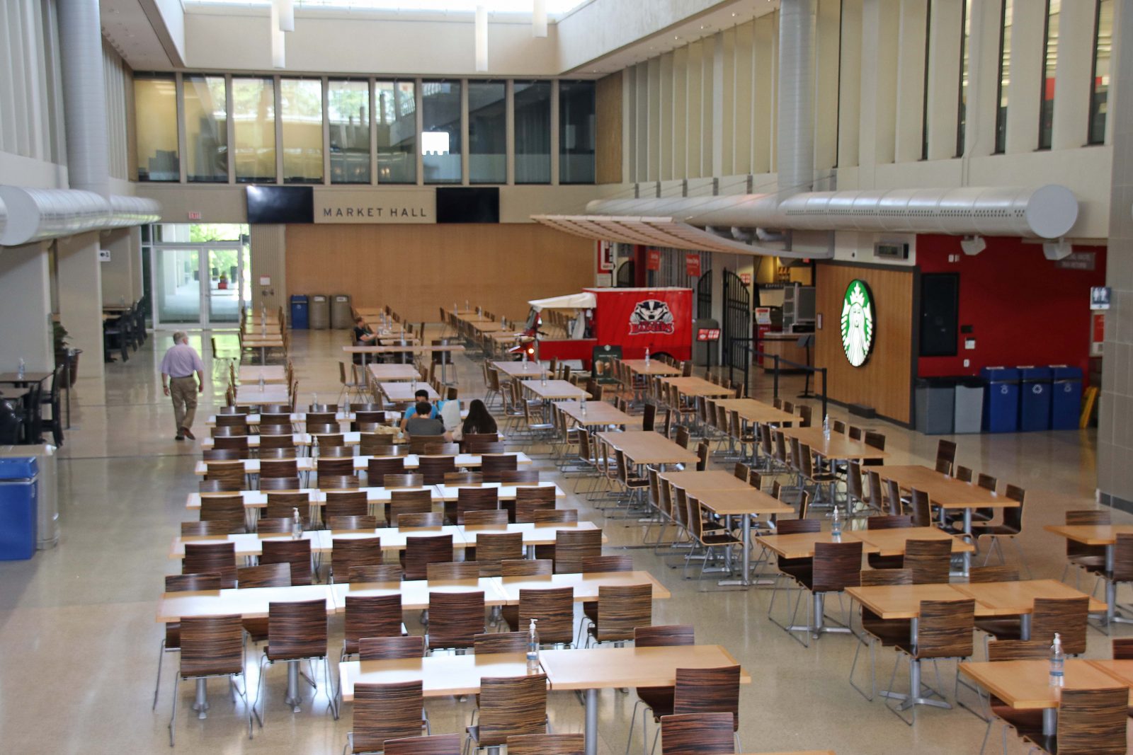 An empty dining hall with rows of chairs and tables.