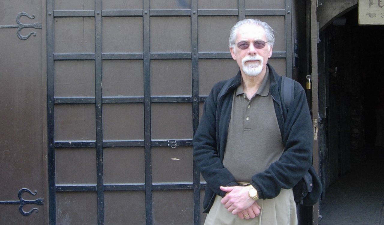 Professor Emeritus Barry Grant stands in front of a commercial haunted house.