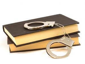 An isolated set of books and handcuffs for the educational study of law and order.