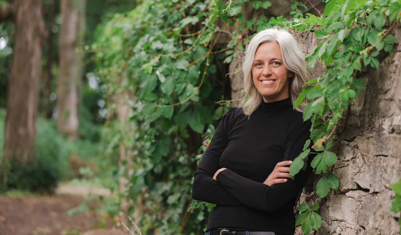 Rachel Rensink-Hoff, leaning against an ivy-covered wall.