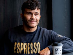 Profile picture of Chris Battagli wearing a sweater that says ‘ESPRESSO’ in gold block letters.