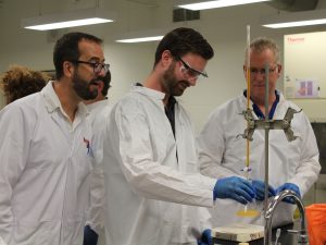 Three men in a lab working with equipment.