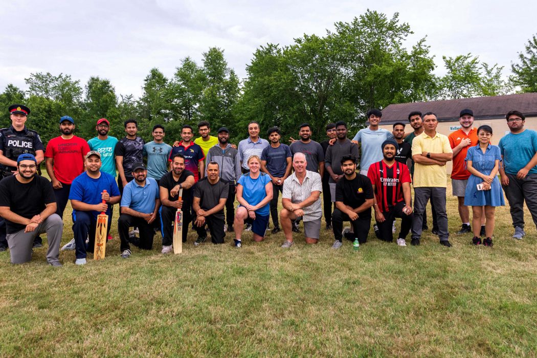 A large group of cricket players pose for a group photo.