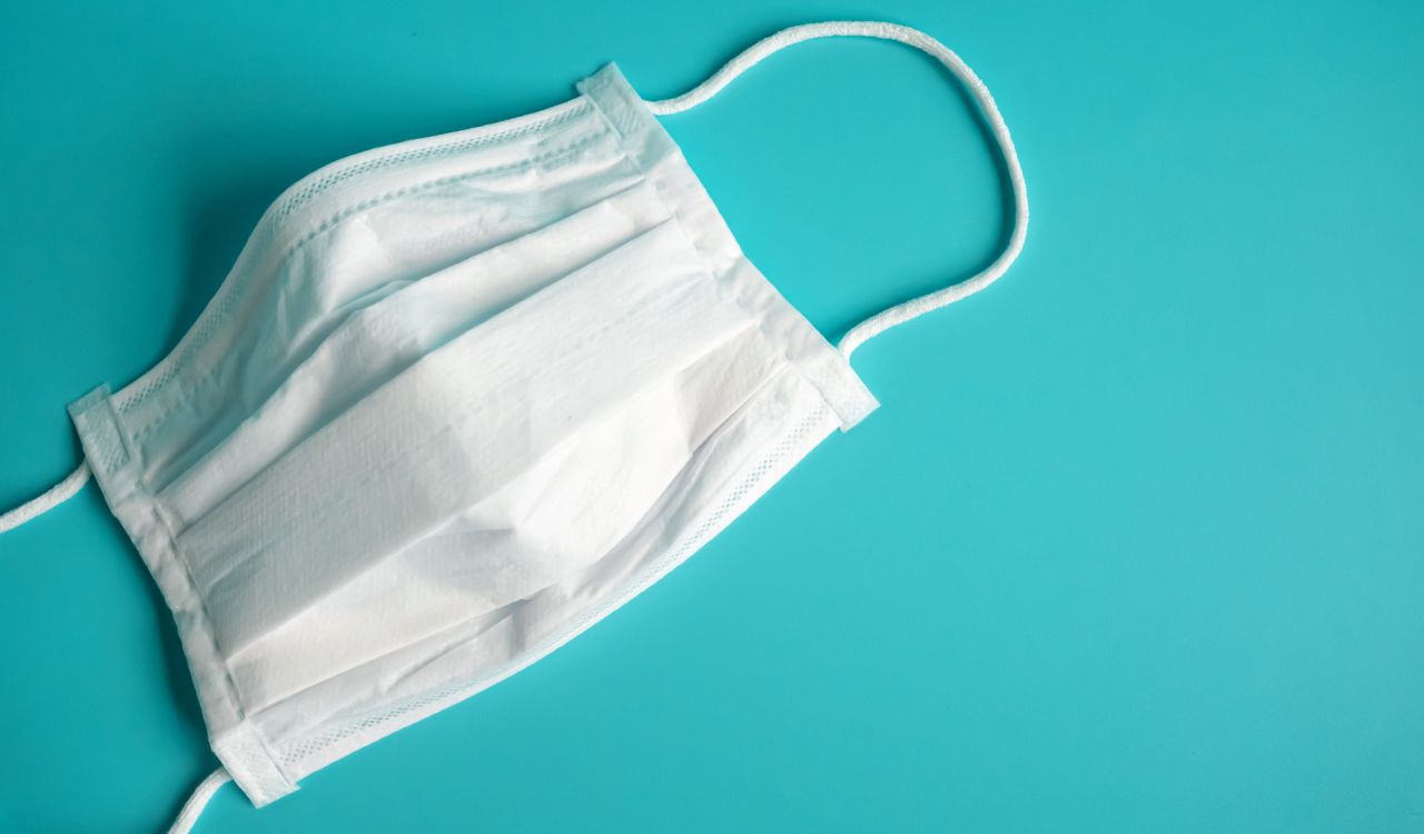 White surgical mask on a blue background.