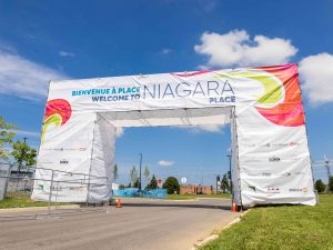 A sign on scaffolding sits over a road. The sign reads ‘Welcome to Niagara Place.’