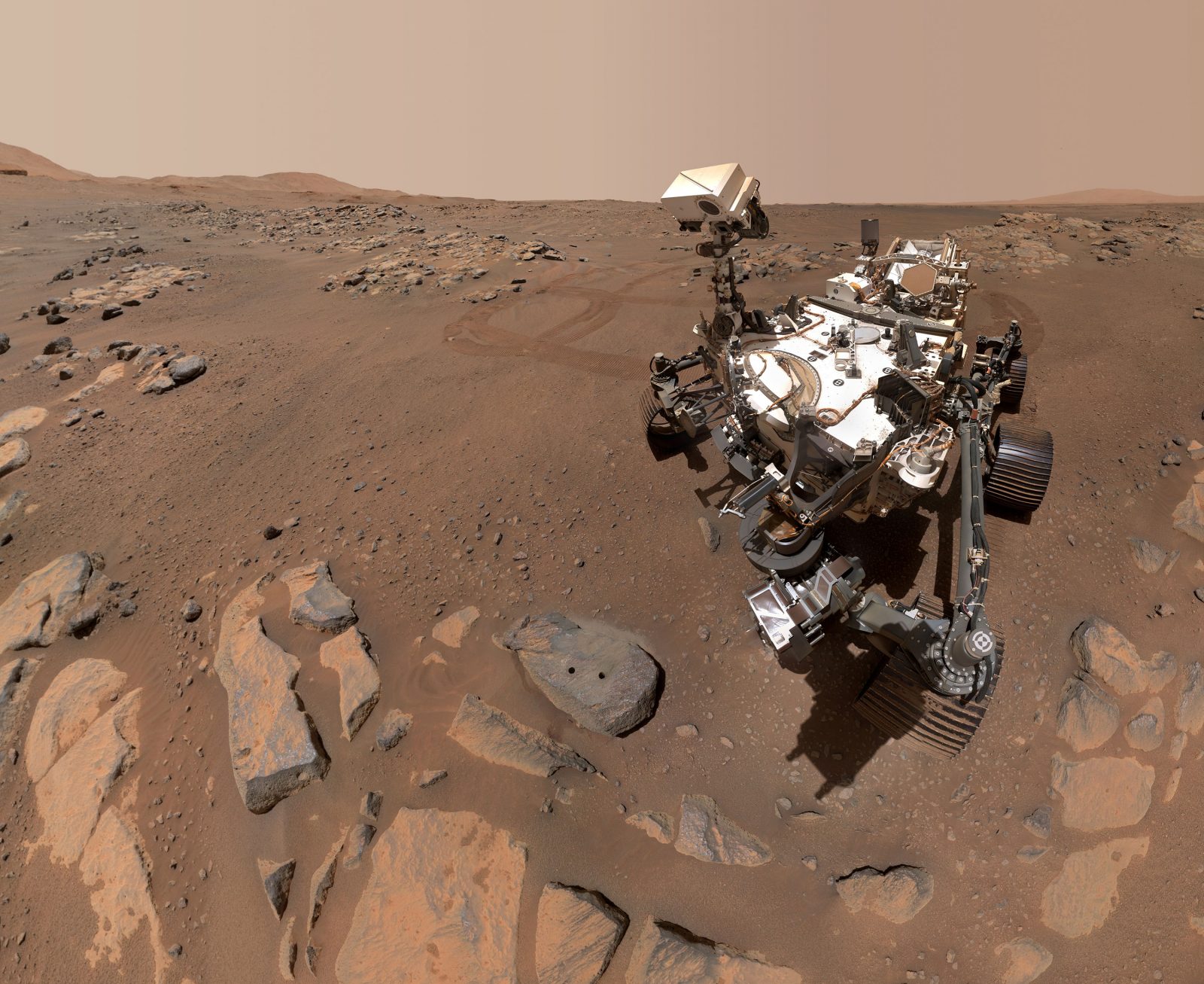 The Mars Perseverance rover on the surface of Mars, a red dusty looking terrain.