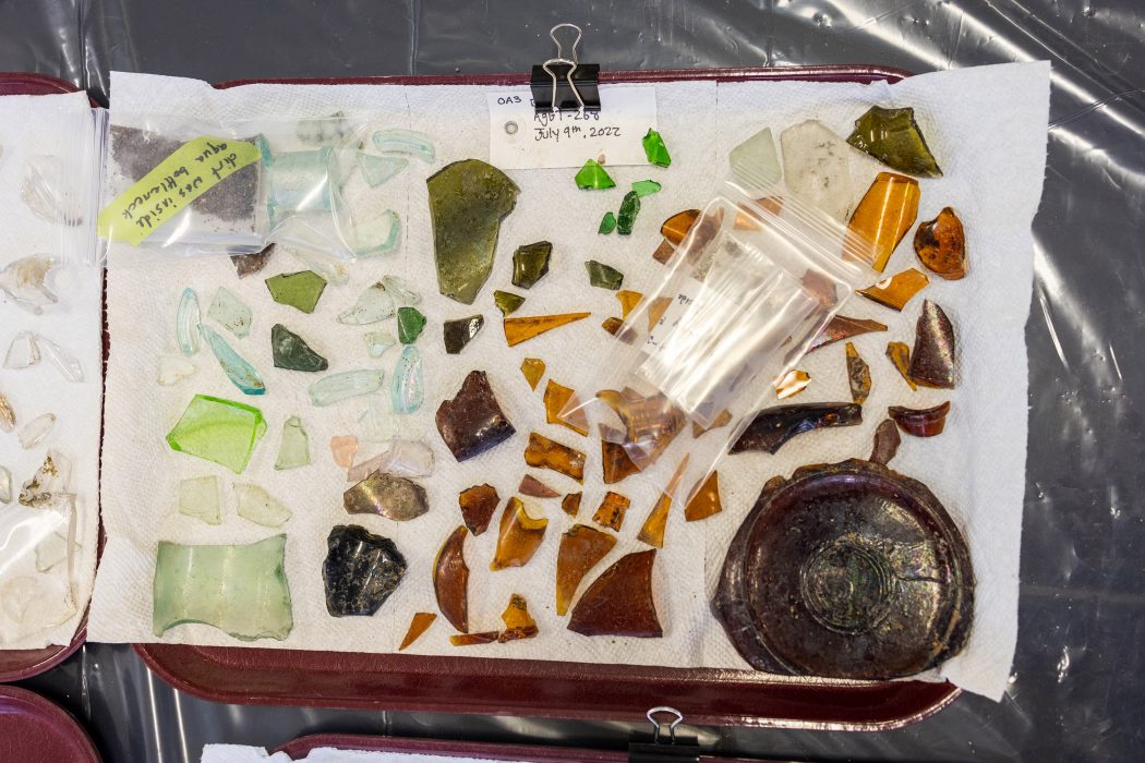 Different coloured pieces of broken glass are displayed on a tray.