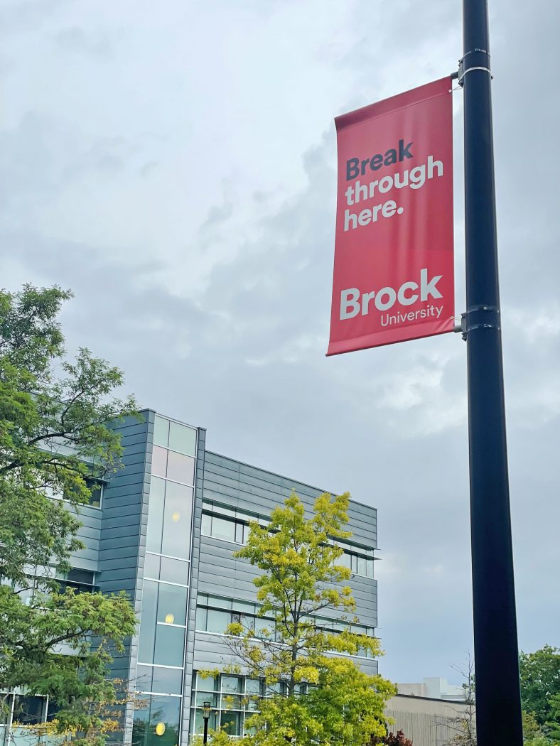 A banner that says 'Break through here' hangs on a light post.