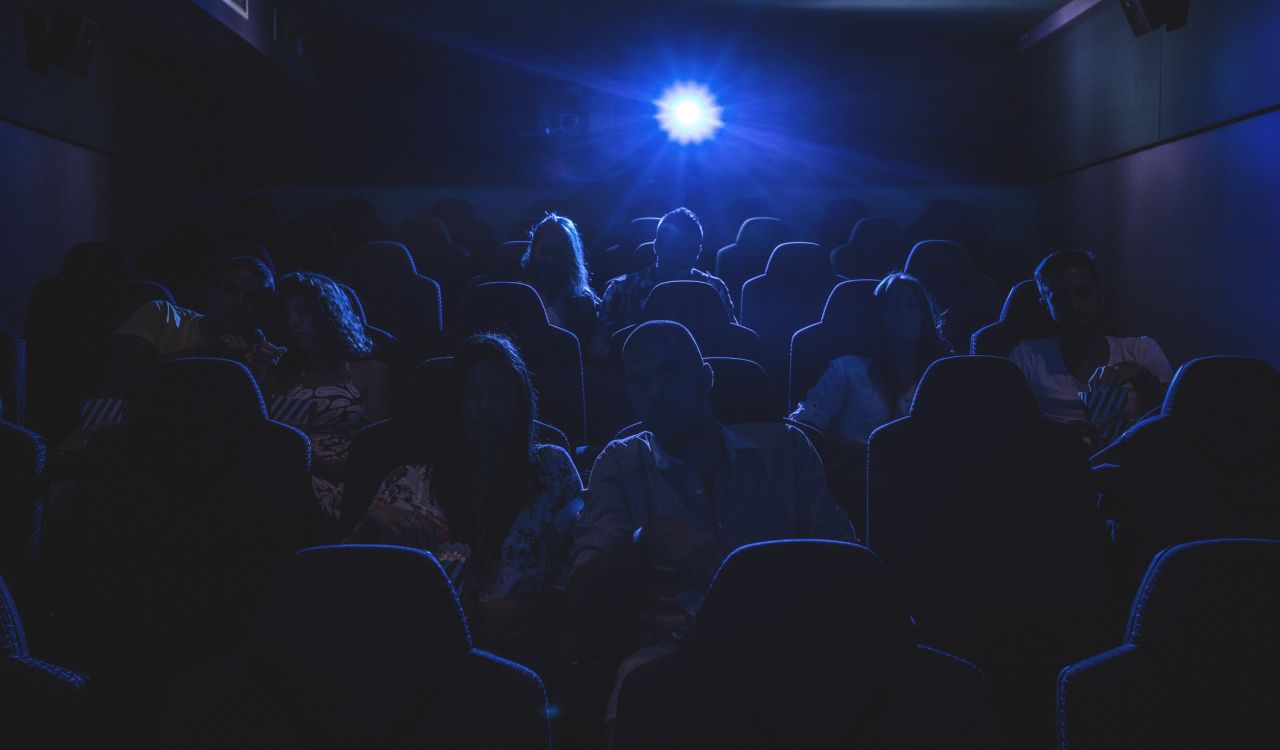Silhouette of people watching a movie in a movie theatre.