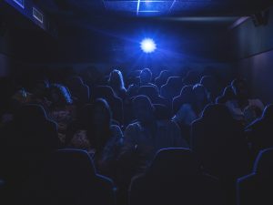 Silhouette of people watching a movie in a movie theatre.