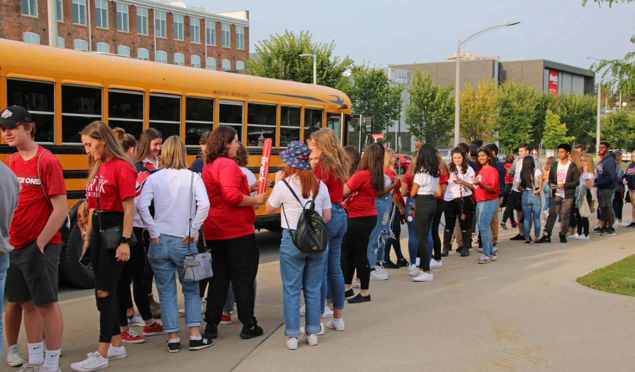 Students line up in front of a school bus.