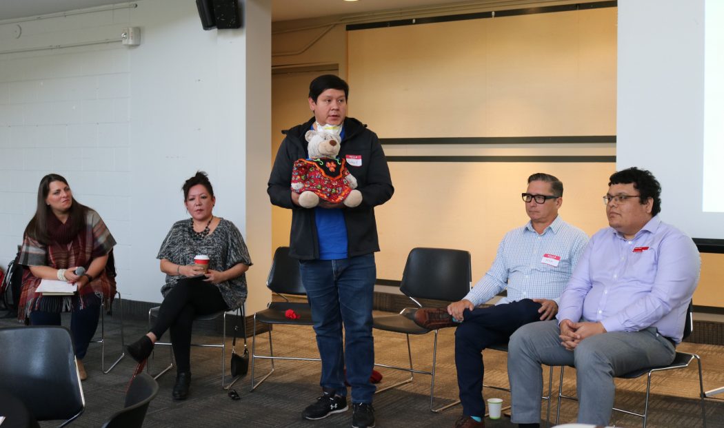 Department of Educational Studies Assistant Professor Stanley (Bobby) Henry holds Brock’s Reconciliation Ambearrister Entiohahathe'te, while speaking about its purpose while panelists listen.