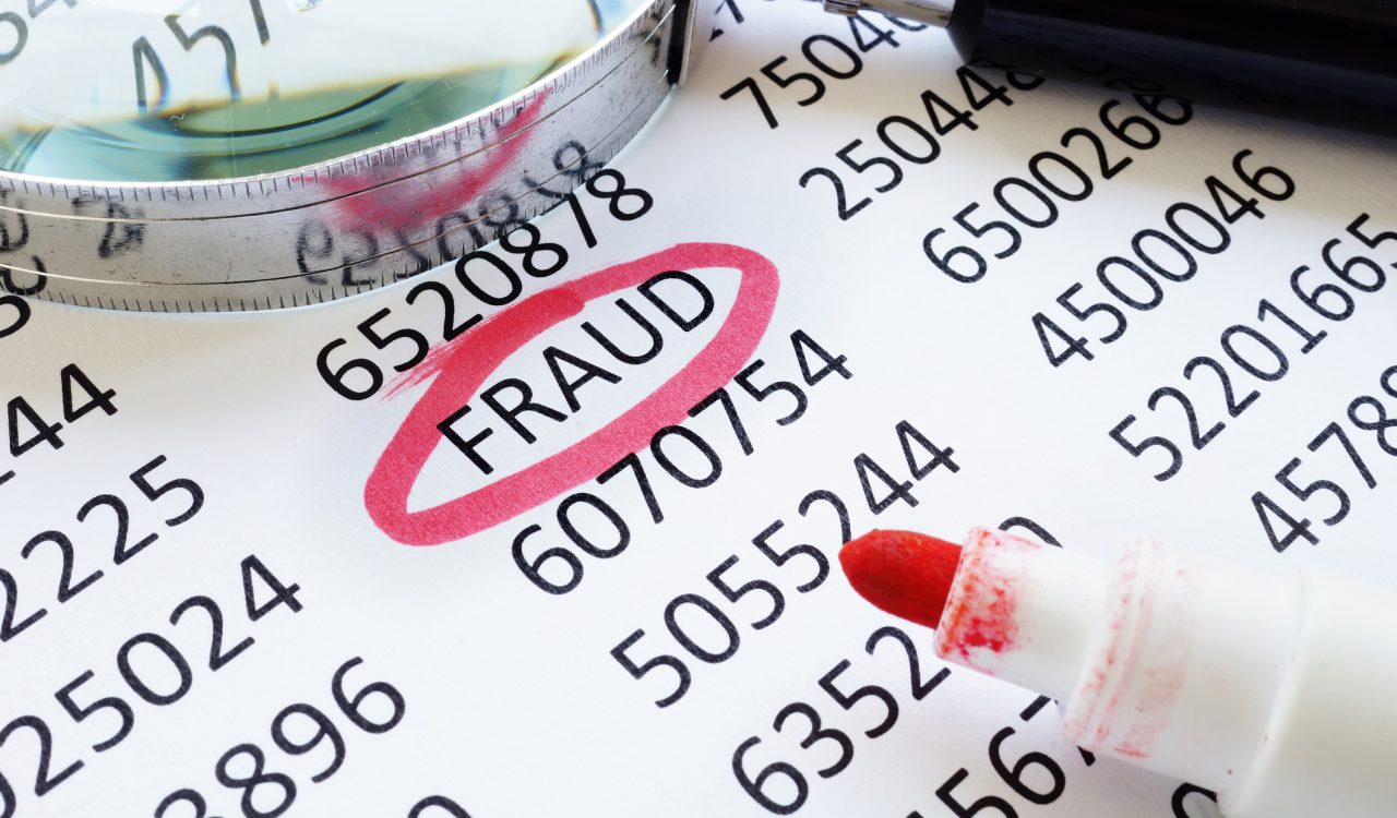 The word FRAUD circled in red on spreadsheet of numbers.