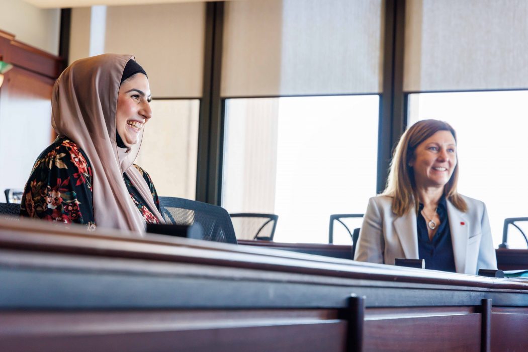 Two women sit at a table together.