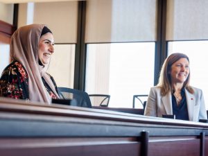 Two women sit at a table together.