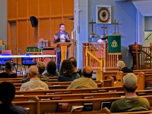 Scott Neufeld addresses an audience inside Silver Spire United Church.