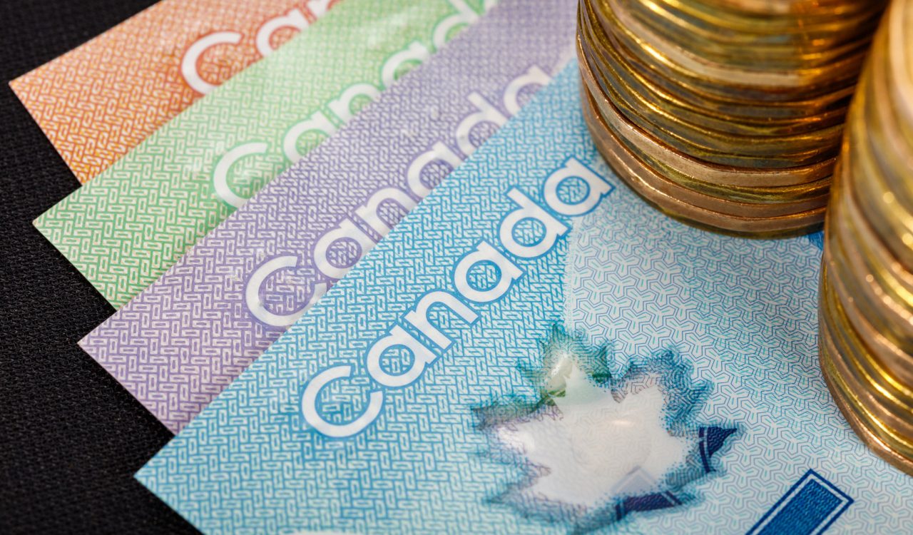 Canadian currency including bills fanned out and two stacks of coins.