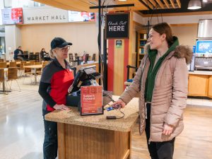 A Brock student and Brock Dining Services retail associate complete a cellphone payment transaction at the Market Eatery.