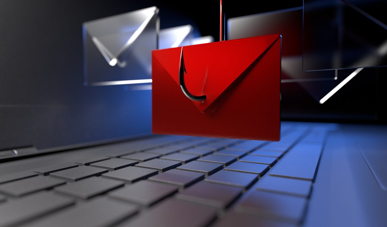 In this close up digital illustration of a laptop computer, a fishing hook snags a red envelope that is hovering over the laptop keyboard. Several other clear envelopes surround the red envelope.