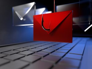 In this close up digital illustration of a laptop computer, a fishing hook snags a red envelope that is hovering over the laptop keyboard. Several other clear envelopes surround the red envelope.