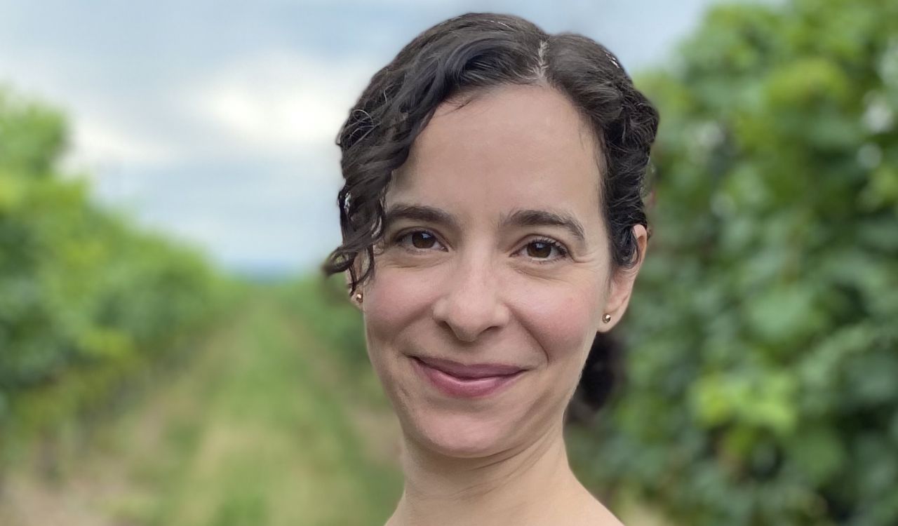 A portrait of Sandra Della Porta in a vineyard.