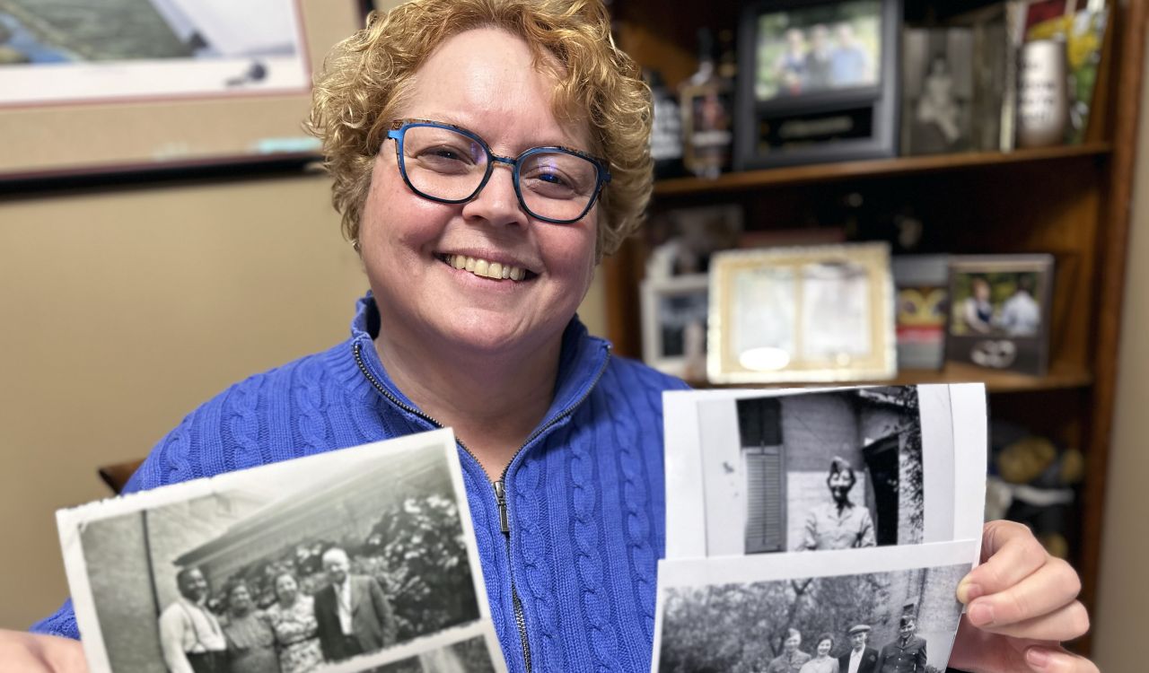 Rosemary Postey uses two hands to hold out old photographs of her family.
