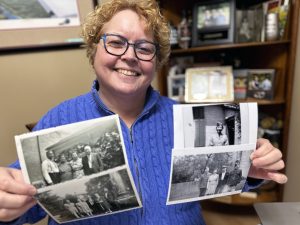 Rosemary Postey uses two hands to hold out old photographs of her family.