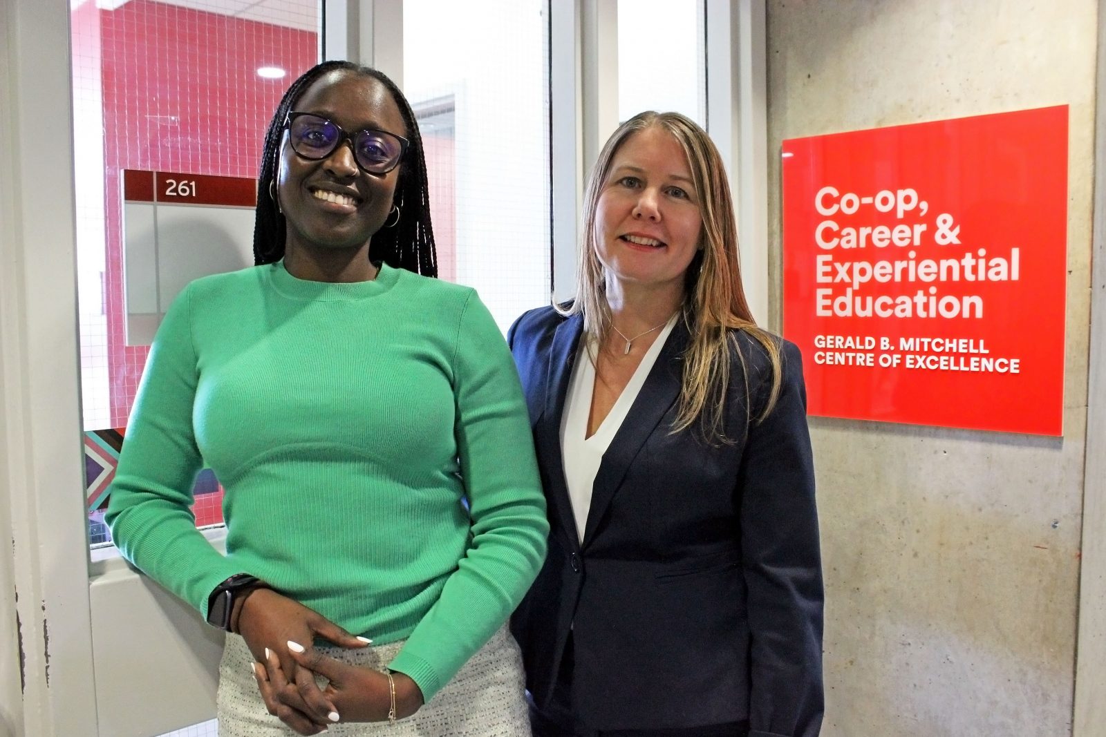 Clelia Kimana and Marisa Brown in front of the sign for the new Gerald B. Mitchell Centre of Excellence, located in TH 265, inside Brock’s Thistle Complex.