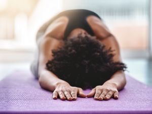 A woman practises yoga on a mat.