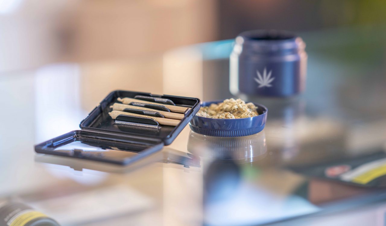 An assortment of cannabis product is laid out and displayed neatly on the counter of a legal retailer.