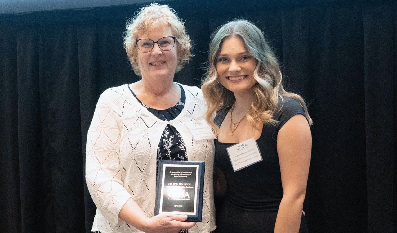 Colleen Hood holds an award while standing with Brock University Students’ Union Vice-President, University Affairs Andrea Lepage.