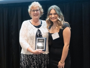 Colleen Hood holds an award while standing with Brock University Students’ Union Vice-President, University Affairs Andrea Lepage.