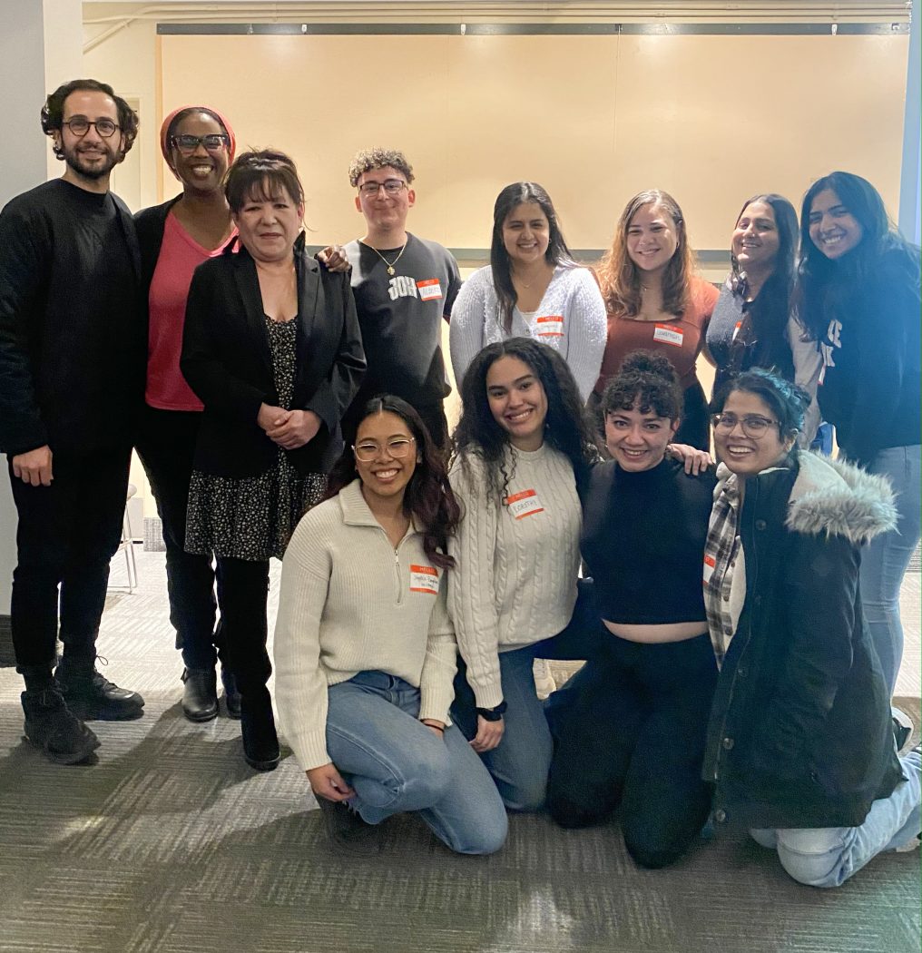 A group of people stands in an indoor meeting space at Brock University.